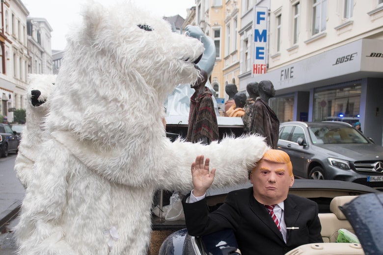 A demonstrator dressed as Donald Trump parades with other activists dressed as polar bears